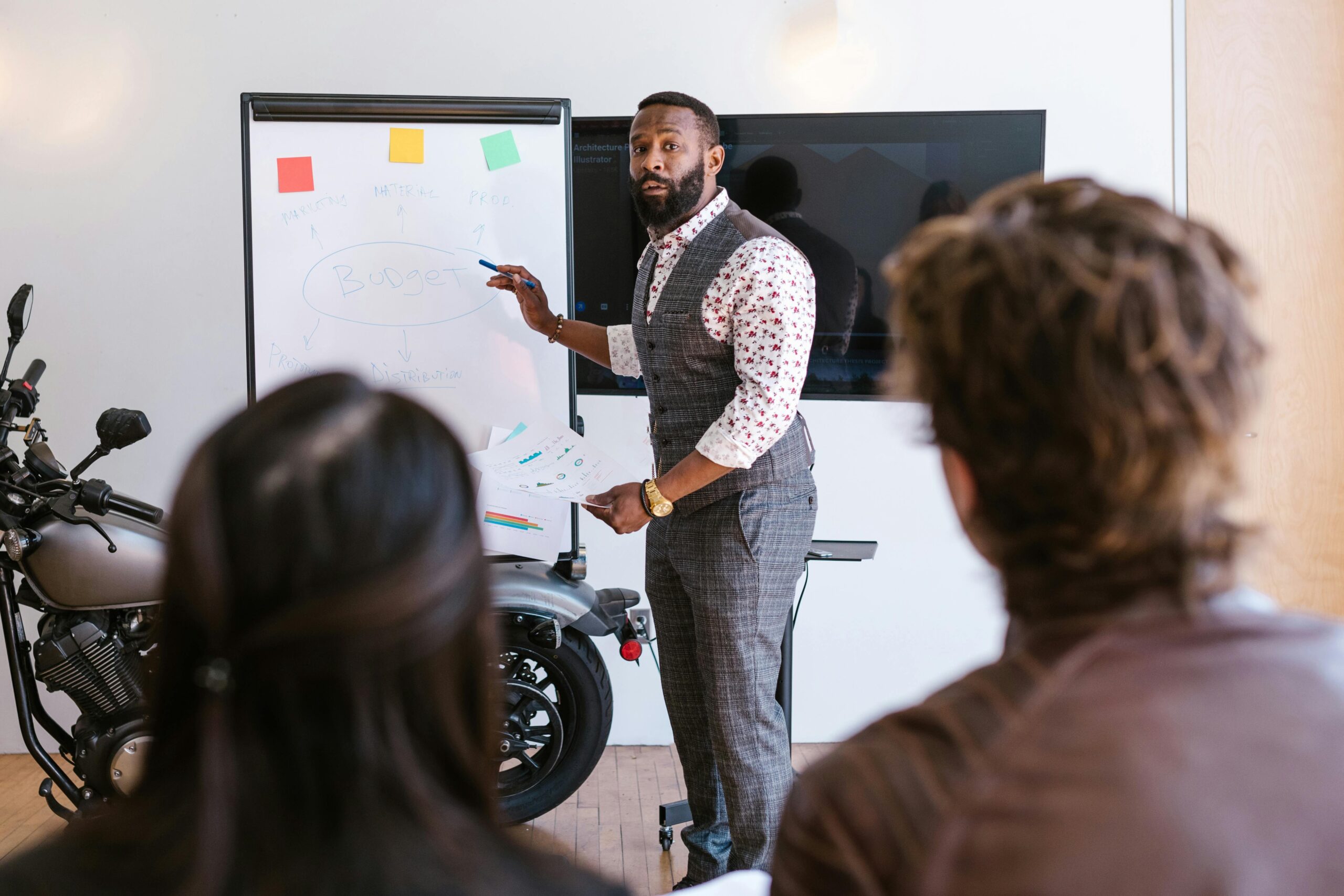 A business professional presenting ideas to diverse team using whiteboard indoors.